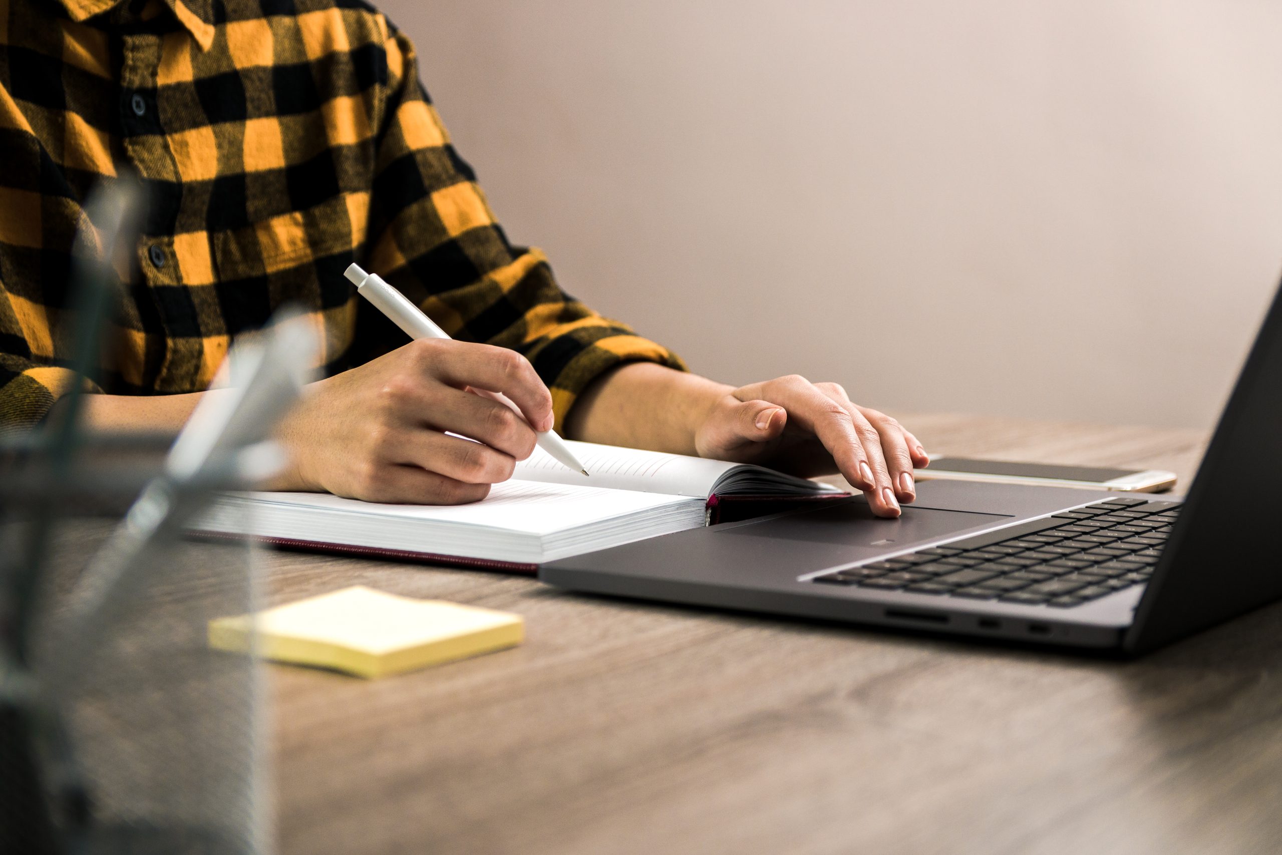 freelancer yellow shirt making notes her notebook scaled